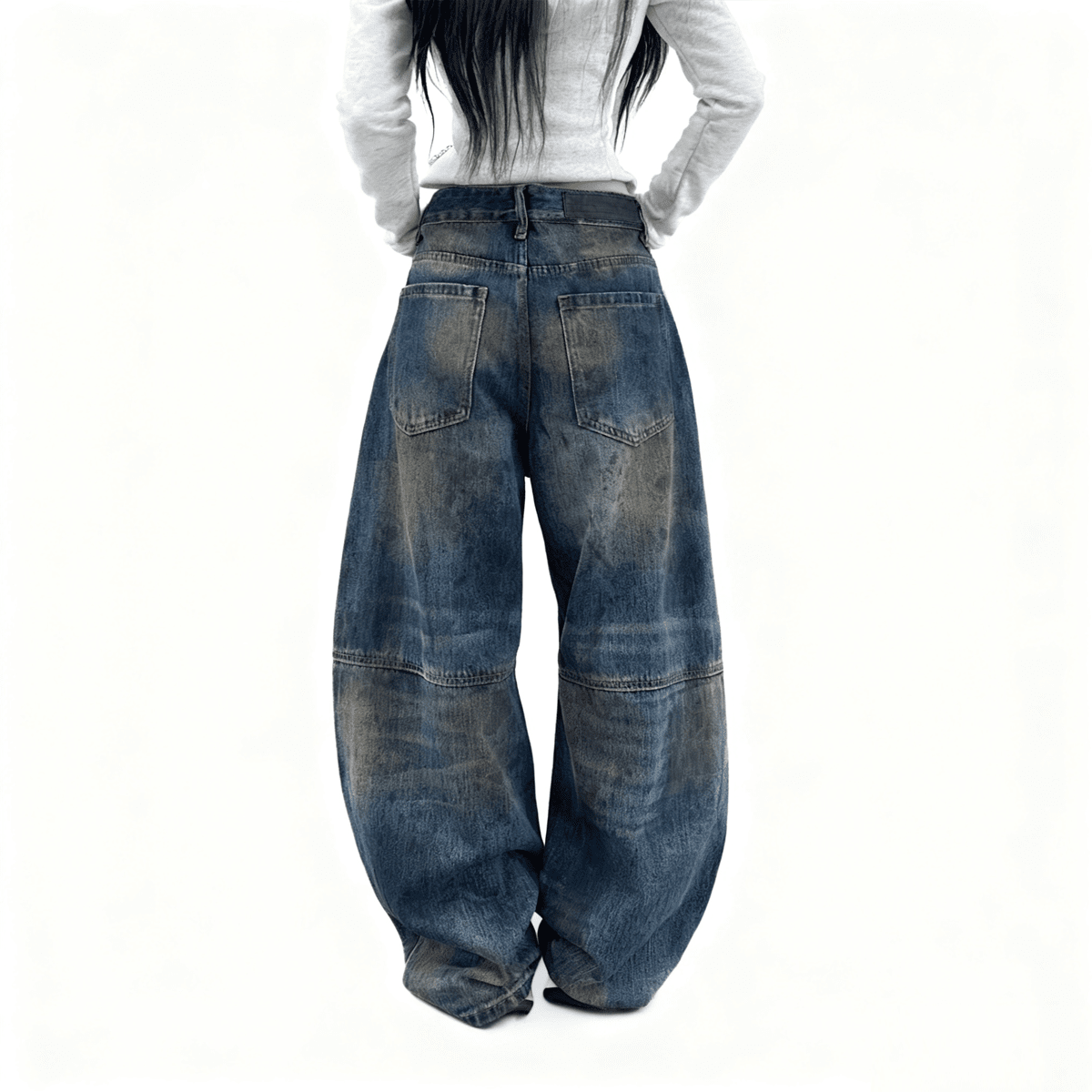 Person wearing wide-leg blue jeans on a white background