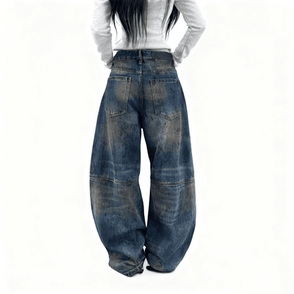 Person wearing wide-leg blue jeans on a white background